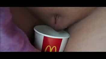 German Blonde girl pees in a milkshakecup